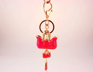 Macro detail of rose pink enamel handbags and rhinestone high heel charm keychain