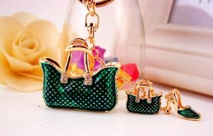 Detailed macro view of green enamel handbag and high heel keychain with white rhinestones
