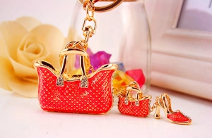 Detail of red rhinestone handbag and high heel charms on a gold-plated metal keychain