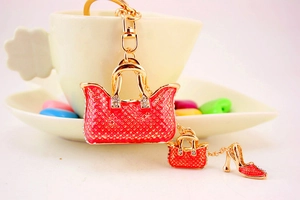 Detail of red enamel handbag and high heel charms on a gold-plated rhinestone keychain