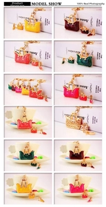 Detailed macro of rhinestone handbag and high heel charms on a gold-plated metal keychain