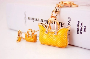 Detail of yellow enamel handbag keychain with gold charms and sparkling rhinestones
