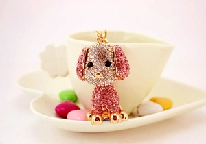 Dettaglio del portachiavi a forma di barboncino dorato con strass rosa brillanti