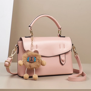 Elegant pink PU leather handbag with a cute brown bear charm and detachable gold strap