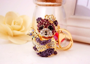 Dettaglio di un portachiavi panda dorato con strass viola e trasparenti e canna di bambù