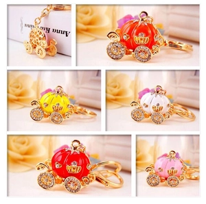 Detail showing various colors of rhinestone pumpkin carriage keychains for women's bags
