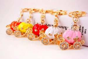 Detailed view of colorful pumpkin carriage keychains with enamel and crystal accents
