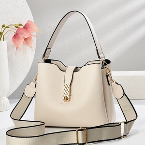 Detail of lychee textured cream bucket bag with wide woven strap and gold metal buckle