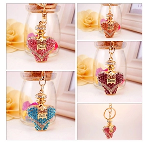 Close-up of crystal rhinestone perfume bottle keychains in pink, purple and blue