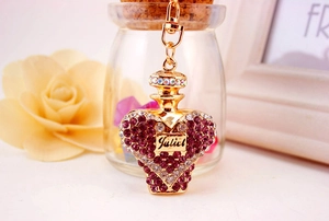 Detail of crystal heart perfume bottle keychain in gold with Juliet engraving