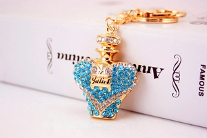 Macro shot of heart-shaped gold keychain with blue rhinestones and Julius engraving