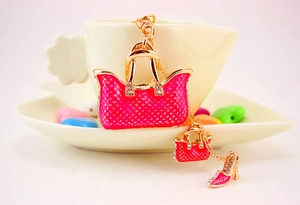 Detailed shot of rose pink handbag and high heel keychain with rhinestones and gold plating