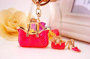 Detail of pink enamel handbag and red high heel keychain with sparkling crystals