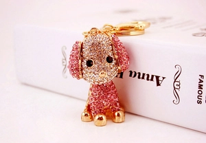 Primo piano di un portachiavi a forma di barboncino con strass rosa e bianchi