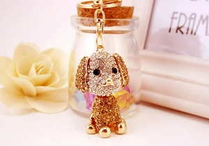 Dettaglio del portachiavi a barboncino con strass e clip dorata su sfondo decorativo domestico