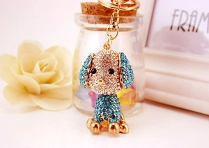 Dettaglio di un portachiavi a forma di barboncino con strass dorati e blu scintillanti