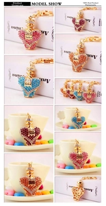 Detail of heart-shaped crystal perfume bottle keychains with Juliet label and pearls