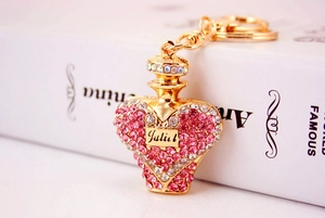 Detailed close-up of crystal-encrusted heart perfume bottle keychain with Juliet script