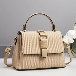 Detail of woven texture handbag featuring gold metal buckle and leather strap