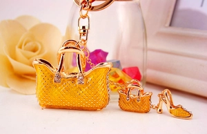 Detailed macro view of a gold-toned handbag and high heel keychain with yellow enamel rhinestones