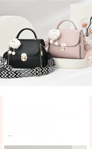 Detail of lychee pattern leather bags with golden locks and wide woven shoulder straps