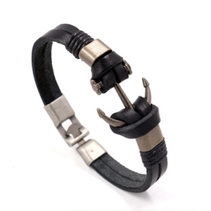 Macro detail of men's black leather bracelet featuring a vintage silver anchor clasp buckle