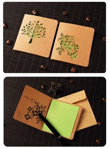 Detail of kraft paper greeting card with hollow tree design and matching green inner sheet