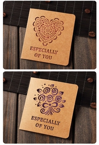 Close-up of vintage kraft greeting cards with heart and bouquet hollow-out designs