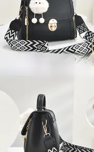 Detail of black lychee grain leather bag featuring wide geometric strap and golden twist lock