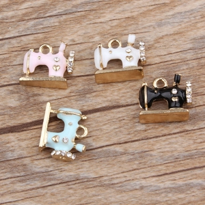 Macro shot of colorful enamel sewing machine charms with rhinestones on a wood surface
