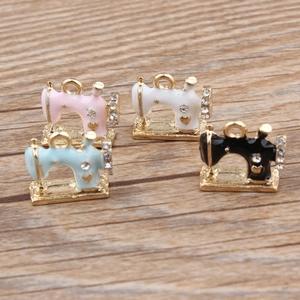 Macro view of gold-plated sewing machine alloy charms with colorful enamel and crystals
