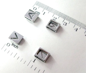 Detailed view of 8mm chrome alphabet slider beads showing size measurement on a scale