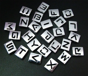 Close-up of silver hollow alphabet beads in zinc alloy for DIY jewelry wristbands