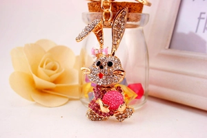 Macro shot of gold rabbit keychain featuring pink rhinestones and a frosted pink ball