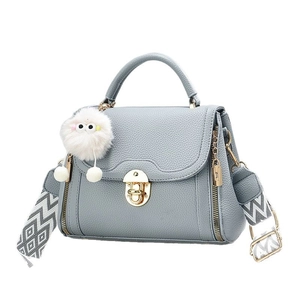 Sac à main en cuir litchi gris-bleu avec bandoulière géométrique et pompon