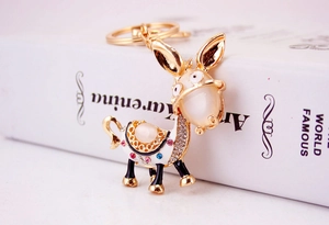 Detail of donkey keychain featuring rhinestones, cat eye stone and golden finish