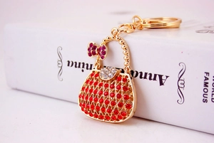 Macro shot of red rhinestone-encrusted handbag keychain with purple bow on book