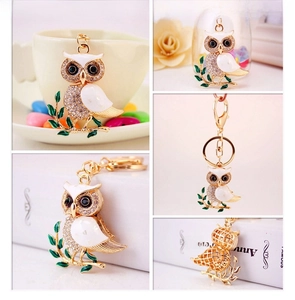 Detail of owl keychain featuring white enamel wings and sparkling crystal rhinestones