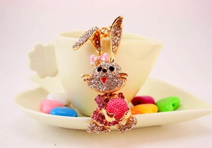 Close-up of golden rhinestone rabbit keychain with pink dress and crystal accents