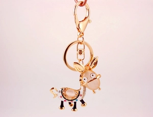 Macro detail of cartoon donkey keychain featuring yellow opals and colorful rhinestones