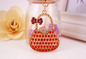 Detailed macro view of red and white rhinestone studded golden handbag keychain pendant