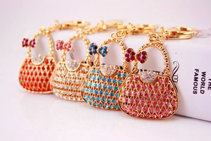 Detail showing four rhinestone handbags metal keychains in red white blue and pink