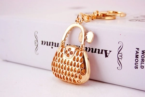 Macro shot of creative golden hollow handbag keychain with rhinestone bear charm detail