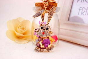 Detail shot of a crystal-studded golden bunny keychain with a purple ball accent