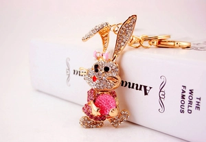 Close-up of a sparkling rhinestone rabbit keychain with a pink bow and golden alloy frame