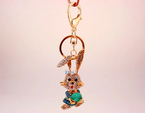 Macro shot of gold rabbit keychain featuring sparkling crystals and a green gem accent