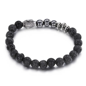 Lava rock beaded bracelet with silver Buddha head and hematite stones on grey background