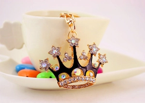 Close-up of golden crown keychain with black enamel and colorful rhinestones