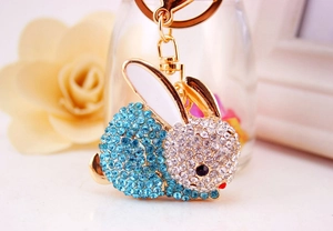 Macro d'un porte-clés lapin doré avec strass bleus et oreilles en émail blanc