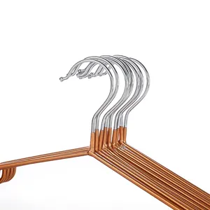 Detail of rose gold metal hangers featuring non-slip notches and chrome hooks for clothes